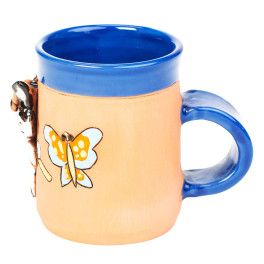 Blaue Keramiktasse mit einer Schmetterling fangenden Katze