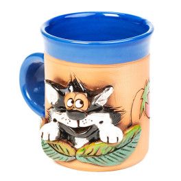 Blaue Keramiktasse mit einer Katze hinter einem Erdbeerenbusch